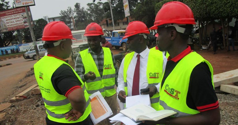 Construction workers wearing 'CoST' branded vests
