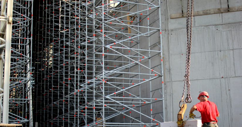 Construction worker, lifting a block in a construction site.